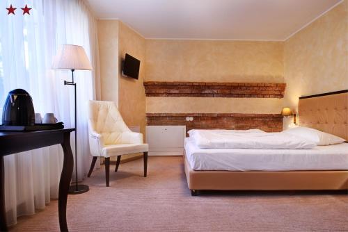 a hotel room with a bed and a chair at Romantic Boutique Hotel & Spa in Panevėžys
