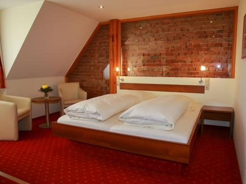 a bedroom with a bed and a brick wall at Gästehaus Gühring in Rosenfeld