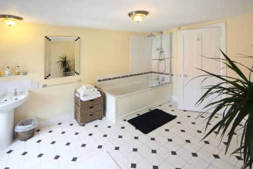 a bathroom with a tub and a sink and a mirror at Bawdsey Hall in Bawdsey