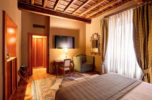 a bedroom with a bed and a chair and a table at Hotel Valadier in Rome
