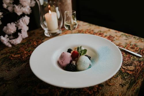 a white plate with desserts on a table at Romantic Boutique Hotel & Spa in Panevėžys