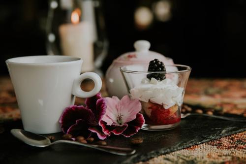 a table with a cupasteryasteryasteryasteryasteryasteryasteryasteryasteryasteryastery at Romantic Boutique Hotel & Spa in Panevėžys