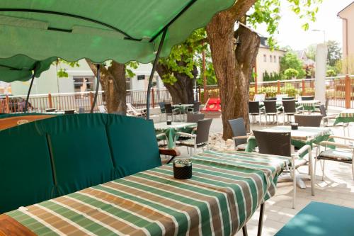 a table with a green umbrella on a patio at Hotel Guidassoni in Leibnitz