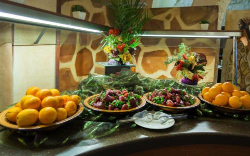 a buffet with plates of fruits and vegetables on a counter at Africa Jade Thalasso in Korba