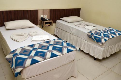 two beds sitting next to each other in a room at Astro Palace Hotel in Uberlândia