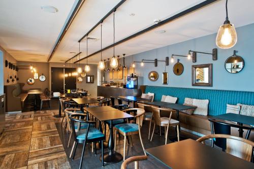 a restaurant with tables and chairs and lights at Urban Lodge Hotel in Amsterdam
