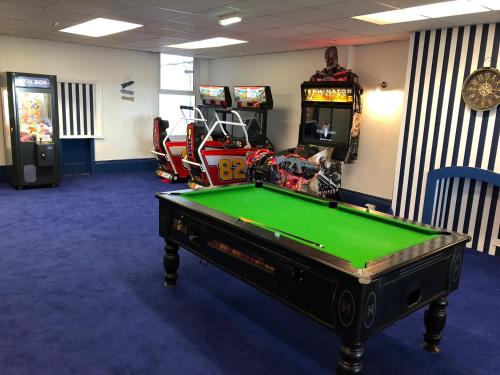 a room with a pool table and arcade machines at Tiffany's Hotel in Blackpool