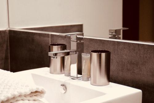 a bathroom sink with two faucets and a mirror at Domaine de Perches in Gaillac