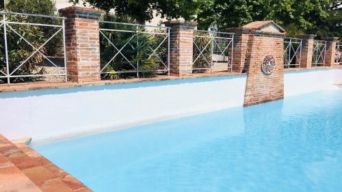 a swimming pool with blue water and a fence at Domaine de Perches in Gaillac