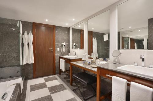 a bathroom with two sinks and a large mirror at Windsor Marapendi Hotel in Rio de Janeiro