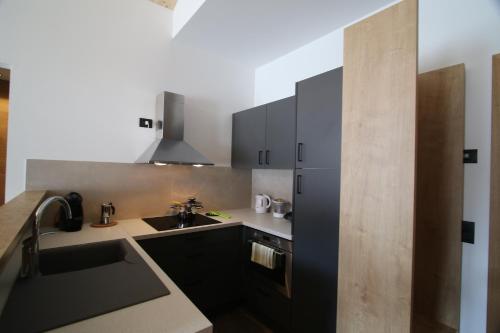 een keuken met zwarte kasten en een wastafel bij Chalet Teresa in Livigno