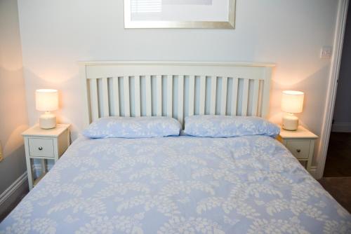 a bedroom with a blue bed with two lamps at Seaview in Worthing