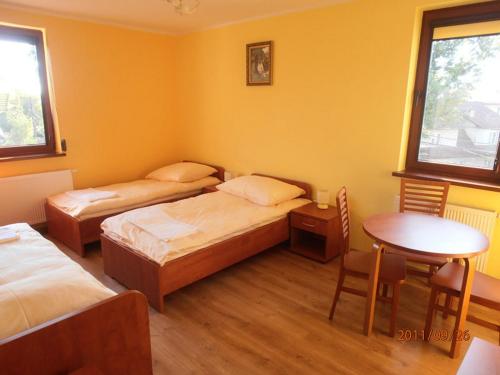 um quarto com duas camas e uma mesa e uma mesa e cadeiras em Ave Łagiewniki na Cracóvia
