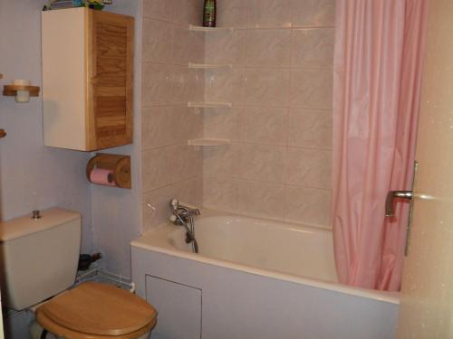 een badkamer met een bad, een toilet en een douche bij appartement in Métabief