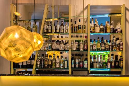 a shelf filled with lots of bottles of alcohol at Hotel Kossak in Kraków