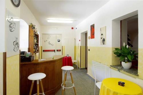 a room with a yellow counter and two stools at Ostello Ou Crierel in Lillianes