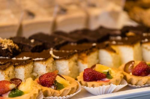 a plate of food with muffins with strawberries on it at Hotel Kossak in Kraków