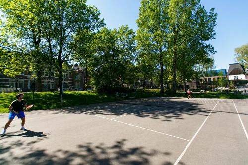 two people playing tennis on a tennis court at Hotel Arena in Amsterdam
