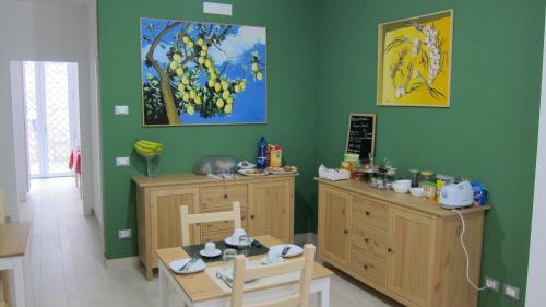 a dining room with green walls and a table and chairs at Federico Secondo B&B in Palermo