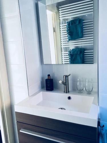 a bathroom with a white sink and a mirror at B&B Het Rode Hert in Doesburg