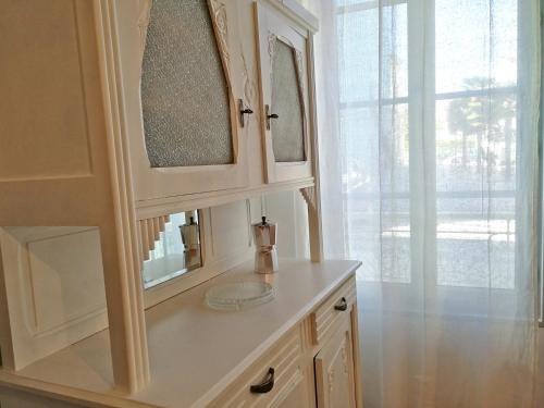 une salle de bain avec un lavabo et deux miroirs dans l'établissement La Loge du Theatre - Saintes, à Saintes