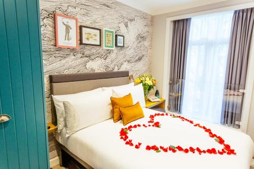 a bedroom with a bed with a heart decoration on it at Oliver Plaza Hotel in London