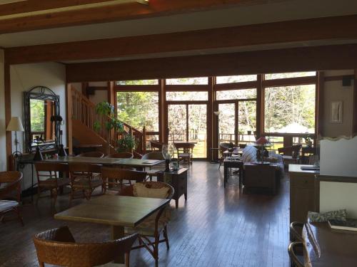 a restaurant with tables and chairs and large windows at Woody Hotel & Restaurant YUMEKOUBOU in Tsurui