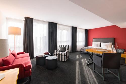 
a living room filled with furniture and a large window at THE MADISON Hotel Hamburg in Hamburg
