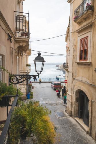 an alley with a view of the ocean between two buildings at Ficupalas in Siracusa
