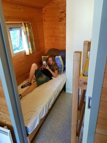 a girl laying on a bed in a cabin at Vejle City Camping in Vejle
