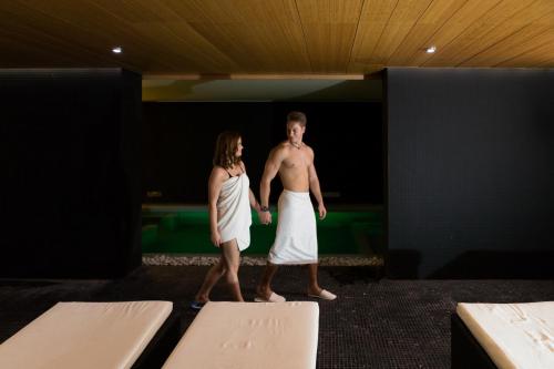 a man and a woman standing in a room at Hotel Zena Beauty & Shopping Center in Hévíz