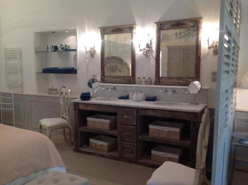 une salle de bain avec un lavabo et un miroir dans l'établissement Les Colombes, à Lagnes