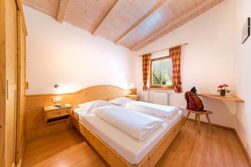 um quarto com uma cama, uma secretária e uma janela em Pardellerhof Ferienhaus em Luson