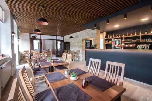 a restaurant with wooden tables and chairs and a bar at Penzion HORA in Ratiboř