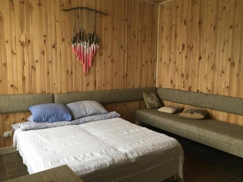a bedroom with a bed in a wooden wall at Baron Munchausen Guest House in Kamianets-Podilskyi