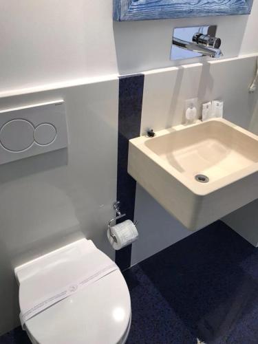 a bathroom with a white toilet and a sink at Le Stanze Di Brando E Nico in Tricase