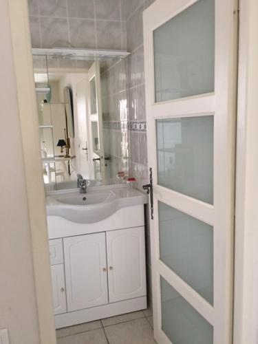 a bathroom with a sink and a mirror and a door at La Bastide des Cades in Aiguines
