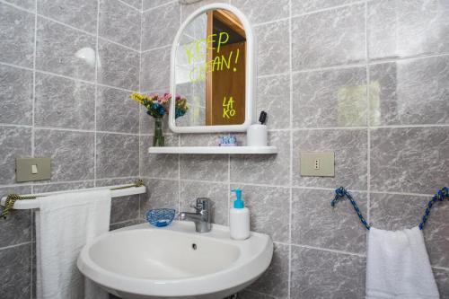 a bathroom with a sink, mirror and bath tub at Lako Hostel in Capodimonte