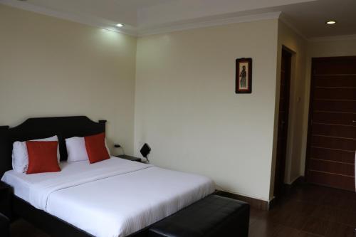 a bedroom with a white bed with red pillows at Gigiri Express Hotel in Nairobi
