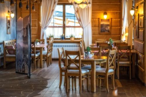 restauracja ze stołami i krzesłami w pokoju w obiekcie Willa Pod Miedzą 200 m do Term w Bukowinie Tatrzańskiej