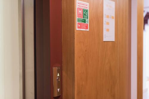 a wooden door with two signs on it at Apartamentos Praça Amarela by Heart of Funchal in Funchal