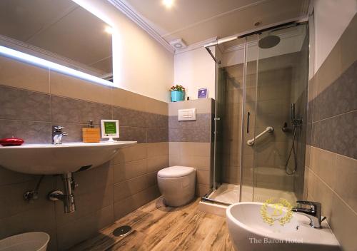 bagno con doccia, lavandino e servizi igienici di Baron Beach Hotel a Scauri