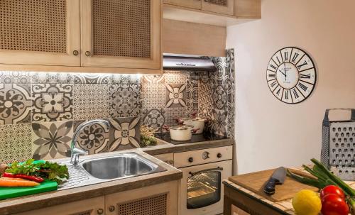 a kitchen with a sink and a clock on the wall at Elvie House in Chania Town