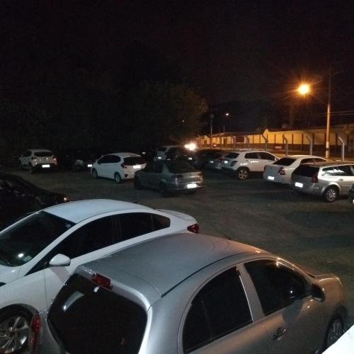 a group of parked cars in a parking lot at night at Santa Catarina Hotel in Aparecida