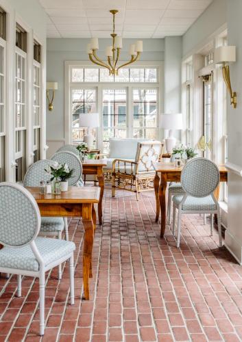 a dining room with chairs and tables and a chandelier at The Bellmoor Inn and Spa in Rehoboth Beach