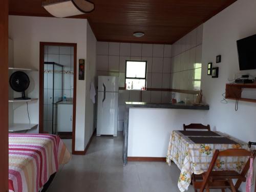 a kitchen with a refrigerator and a bed in a room at Chalé em São Pedro da Serra - Nova Friburgo in São Pedro da Serra