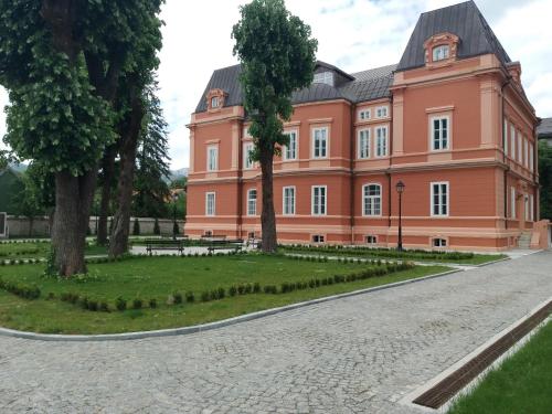 a large orange building with trees in front of it at Apartments Mirković in Cetinje