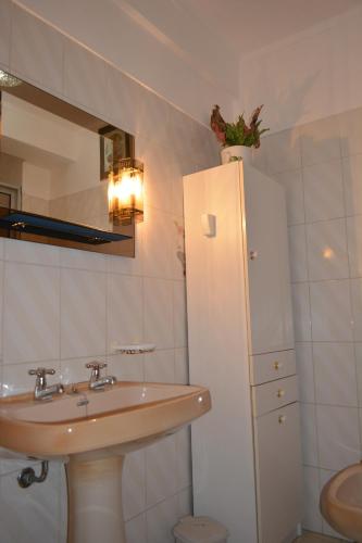 a bathroom with a sink and a white refrigerator at Casa da Praia de Peniche in Peniche