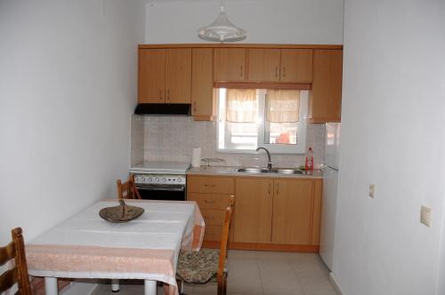 een keuken met houten kasten, een tafel en een wastafel bij Faraggi Richti House in Éxo Moulianá