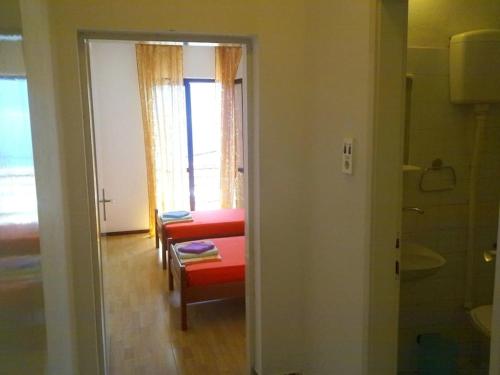 un pasillo con una habitación con una silla y una ventana en Seaside apartments and rooms, en Kotor